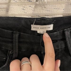 Good American black denim jeans with rips on the knee